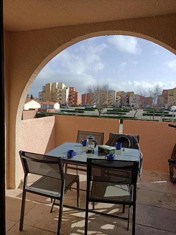 une table et des chaises sur un balcon avec vue sur une ville dans l'établissement pied à terre Port Leucate, à Leucate-Plage