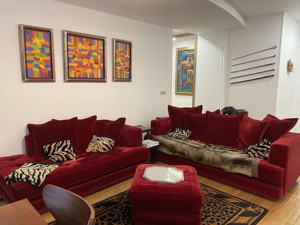 un salon avec deux canapés rouges et une table dans l'établissement Cosy, chic, touristique, à Paris