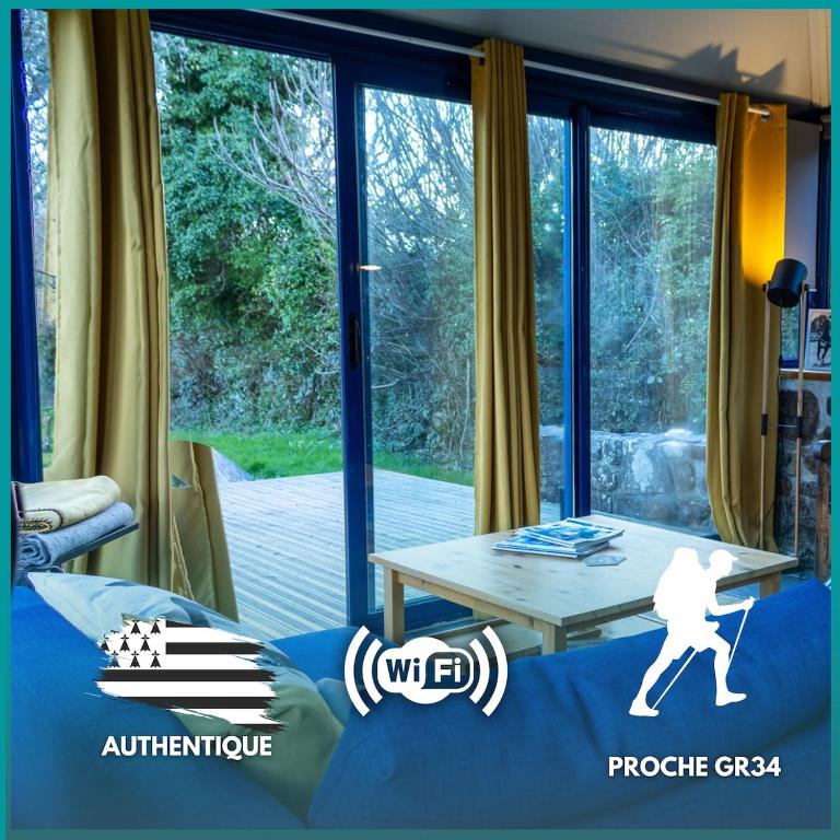 un salon avec une table et une grande fenêtre dans l'établissement Ty Grégoire - Campagne - Wi-Fi, à Crozon