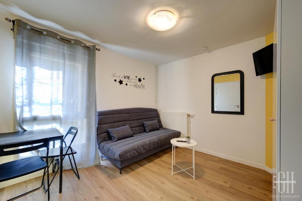ein Wohnzimmer mit Couch und Tisch in der Unterkunft Mercure - Proche A10 -2 V -Parking- Rez-de-chaussée in Saint-Pierre-des-Corps