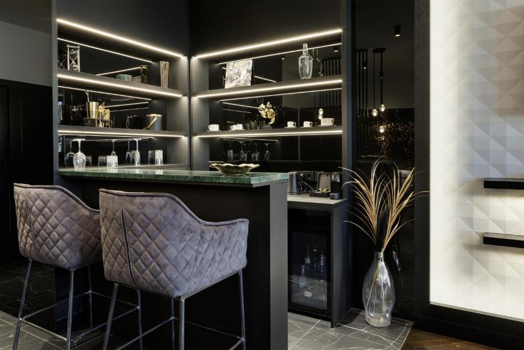 a bar in a black room with two stools at O11 Boutique Hotel Vienna in Vienna