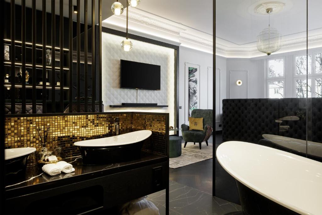 a bathroom with two sinks and a tub and a tv at O11 Boutique Hotel Vienna in Vienna