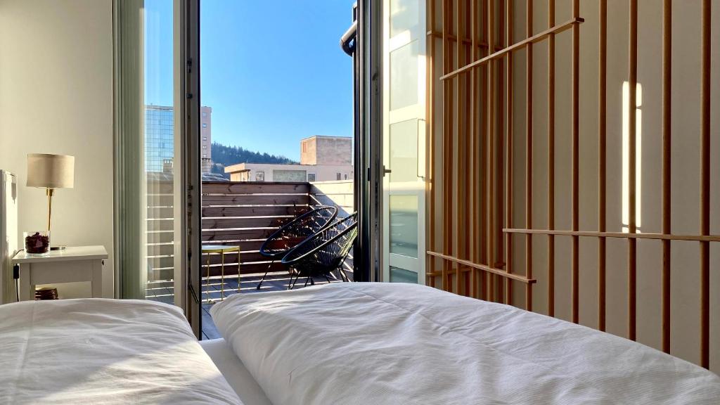 une chambre avec un lit et un balcon avec vue dans l'établissement Little Plaza Duplex, à Ljubljana
