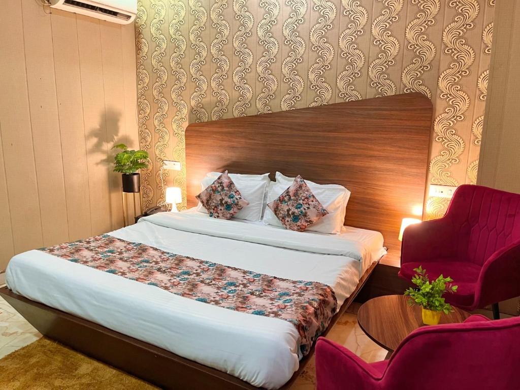 una camera da letto con un letto e una sedia rossa di Hotel Starlet Prime a Chandīgarh