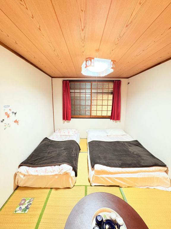 two beds in a room with a window at hostel sunflower202 in Osaka