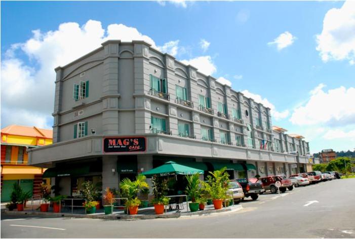 a large building with cars parked in front of it at The Mark's Lodge in Sandakan