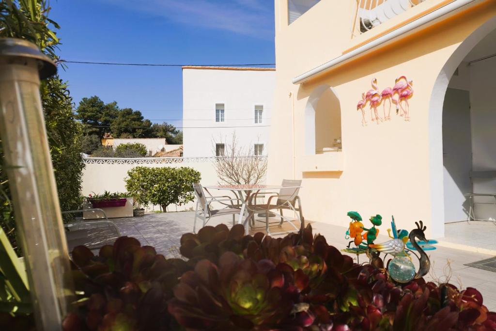 une maison avec un patio avec une table et des chaises dans l'établissement Le Flamant Rose 5 minutes plage Clim 5 Pers, à Fitou