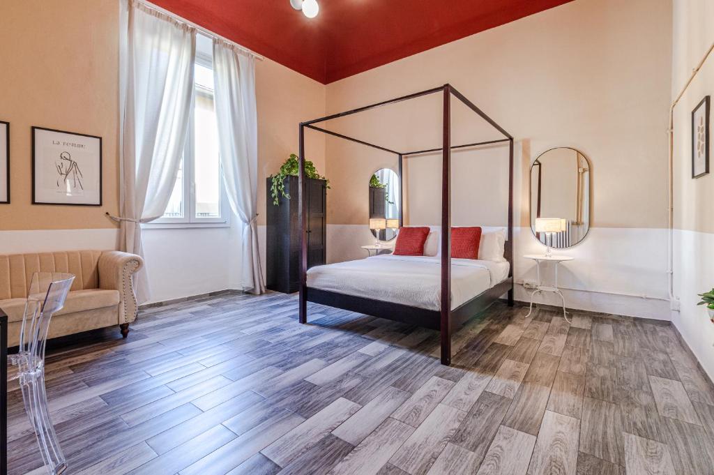 Un dormitorio con una cama con dosel y un sofá. en FLUX your stay, en Florencia