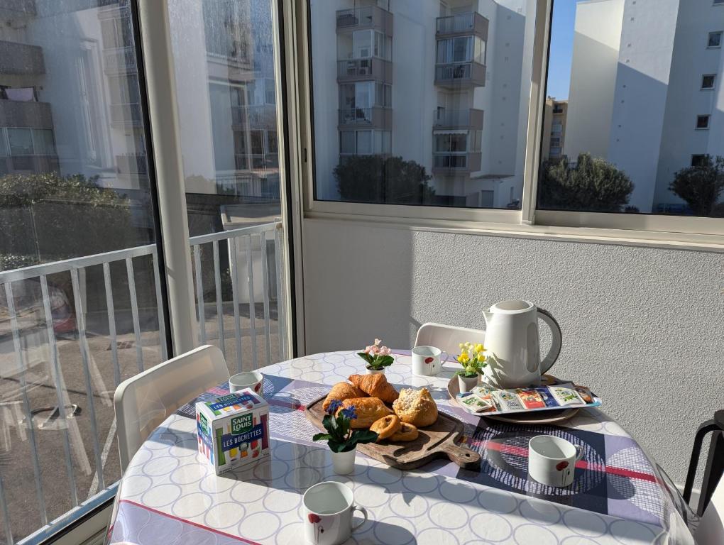 une table avec une assiette de nourriture sur un balcon dans l'établissement Sol-y-Days Sloop appartement 2 chambres avec parking, au Grau-du-Roi