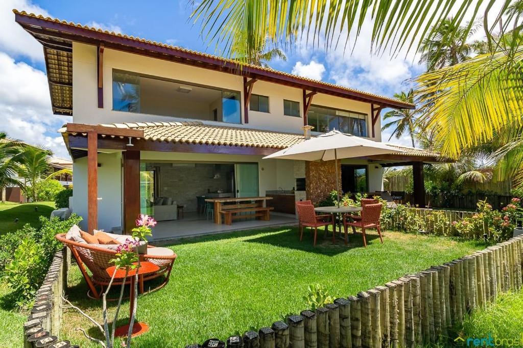 a house with a garden with a table and chairs at Ykutiba Imbassaí - Bangalô - J02 in Imbassai