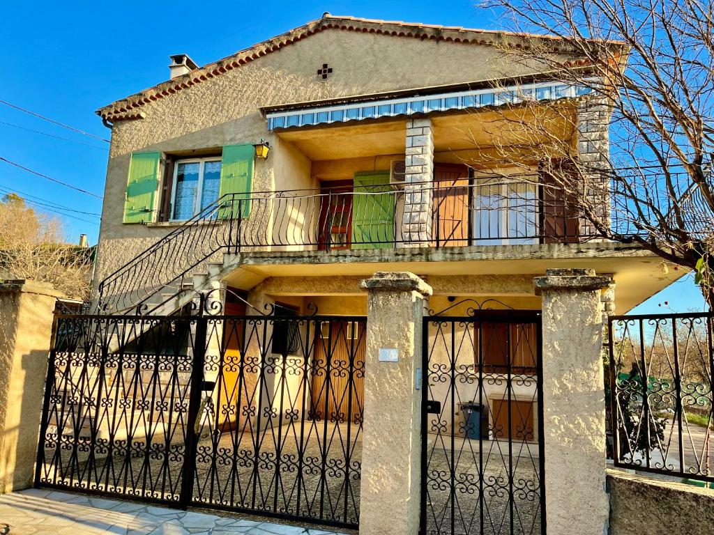 une maison avec une clôture en fer forgé devant elle dans l'établissement Grand Appartement Provençal, à Manosque