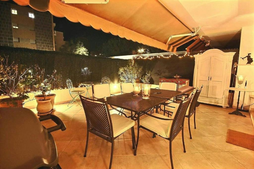 Une table à manger et des chaises sont disponibles sur la terrasse. dans l'établissement magnifique 2 pièces parc de la croisette, à Cannes