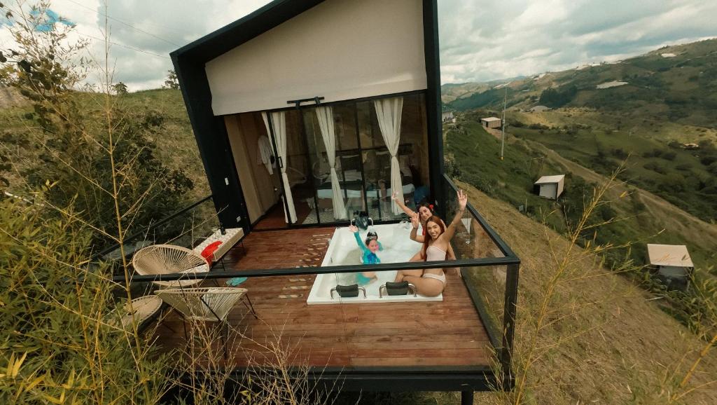 una casa con dos personas sentadas en una bañera en Cabañas para parejas cerca a Medellín - LUUM By Roots Rentals, en Marinilla