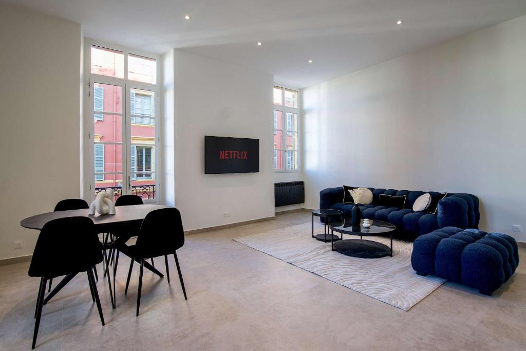 un salon avec un canapé bleu et une table dans l'établissement Massena Infinity, à Nice