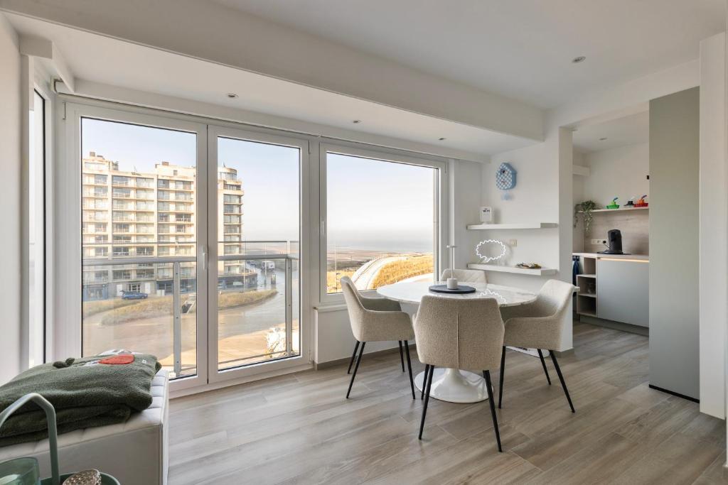 a dining room with a table and chairs and a large window at Appartement San Marino 4B in Middelkerke