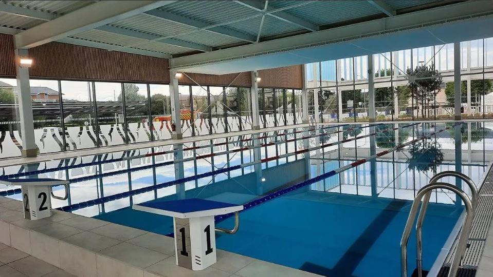 ein großes Schwimmbad in einem großen Gebäude in der Unterkunft Les Frimousses in Cabourg