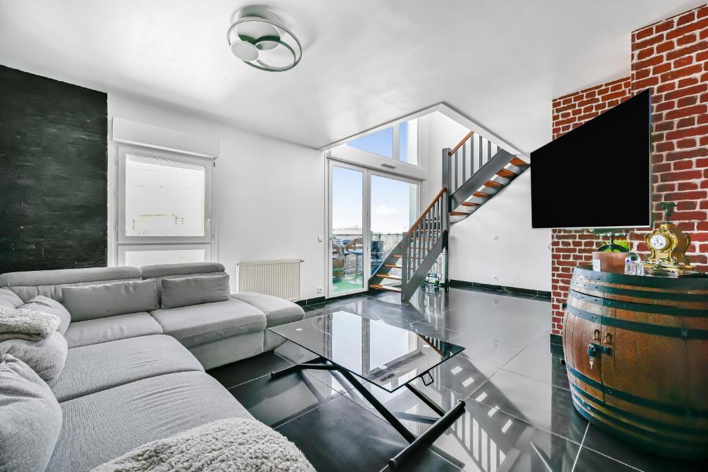 - un salon avec un canapé et un sol en verre dans l'établissement Le Loft - 8p - Balcon - Salle de Sport - Parking, à Pantin