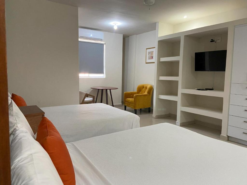 ein Hotelzimmer mit zwei Betten und einem Fernseher in der Unterkunft Nuve Express Corregidora in Torreón