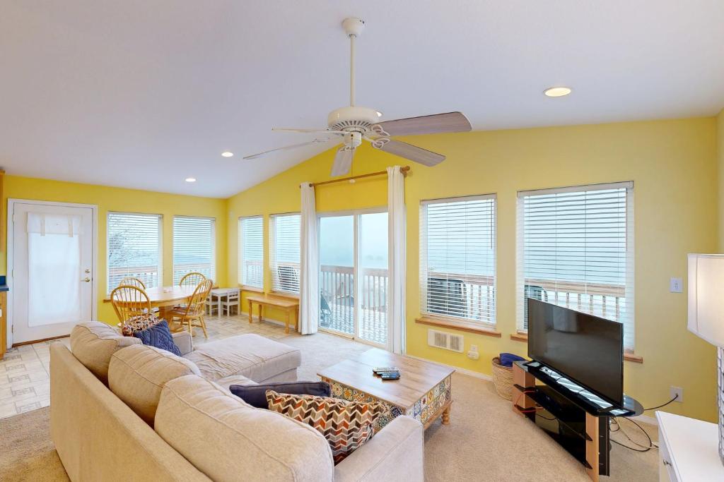 a living room with a couch and a flat screen tv at Hip Nautic in Rockaway Beach