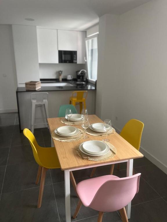 a dining room table with chairs and a pink chair at Mulatas y Mar in Vilagarcia de Arousa