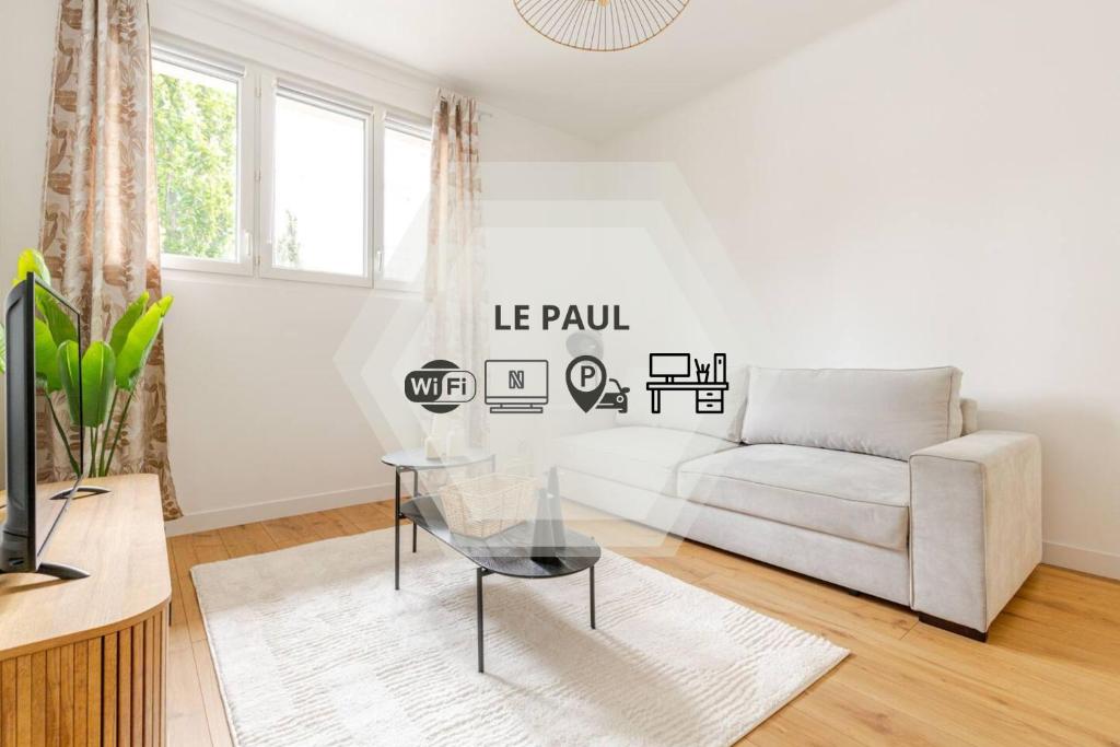 una sala de estar con un sofá y una mesa en Le Paul - Gare - Calme - Jardin, en Saint-Nazaire