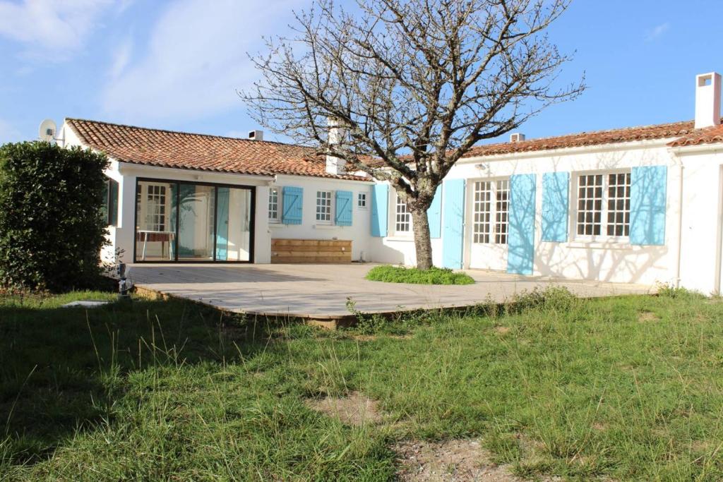 une maison avec un arbre devant dans l'établissement Maison 5 pièces 9 couchages Saint Denis d'Oléron SDO000-335, à Saint-Denis-dʼOléron