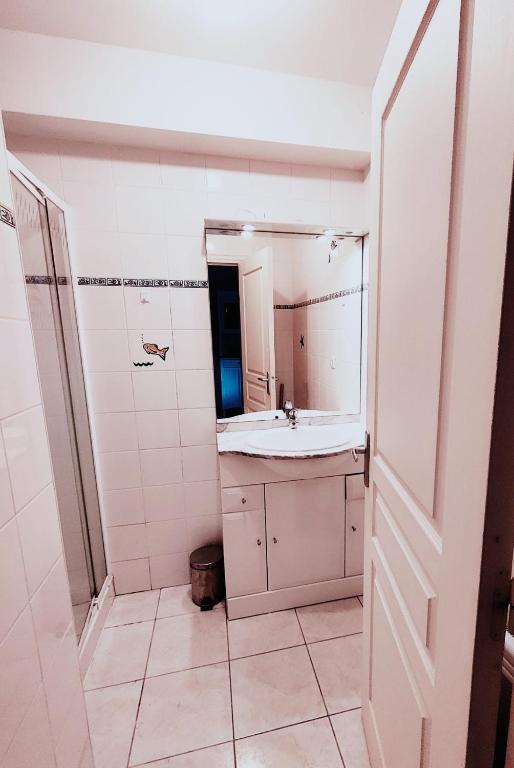 une salle de bains avec un lavabo et un miroir dans l'établissement Escapade cotentine, à Montmartin-sur-Mer