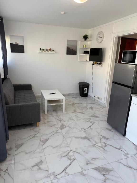 un salon avec un canapé et une table dans l'établissement Carnot - VILLIERS LE BEL proche Aéroport ROISSY CHARLES DE GAULLES & PARIS, à Villiers-le-Bel