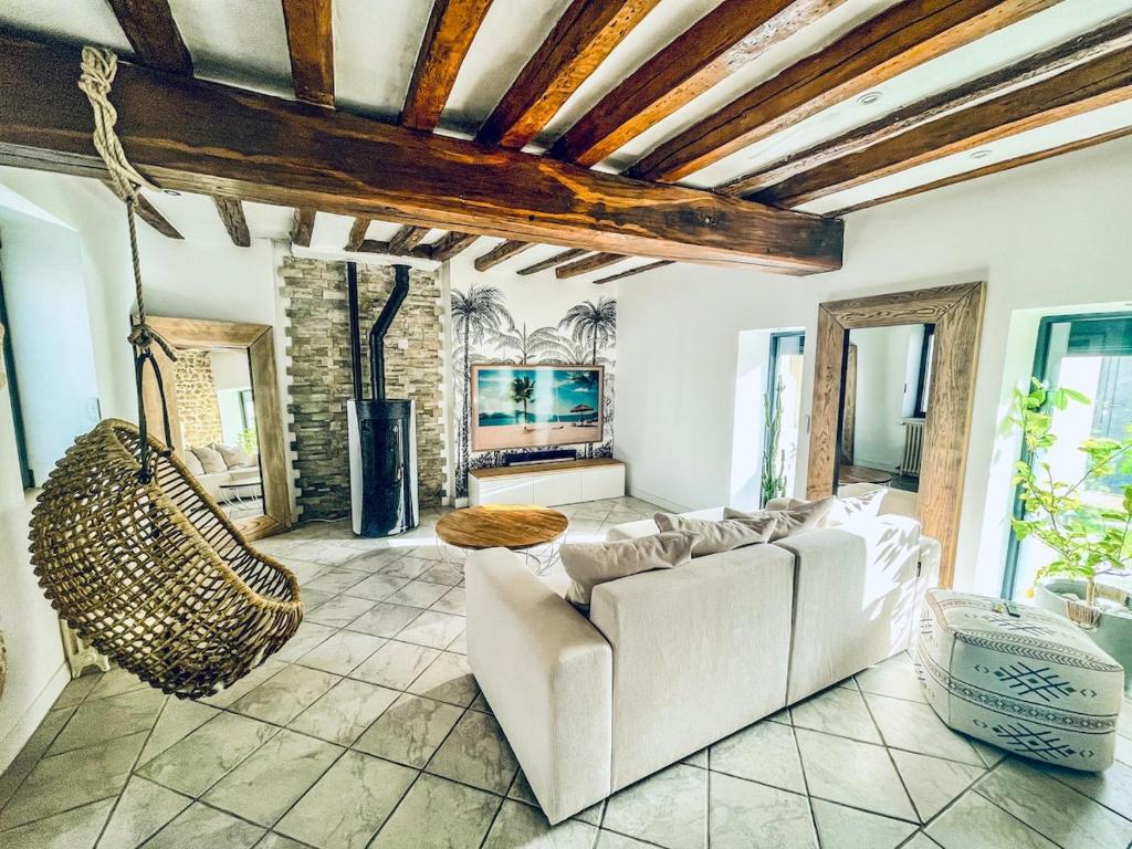 - un salon avec un canapé et une balançoire dans l'établissement Luxurious century-old house with modern decor, à Dordives
