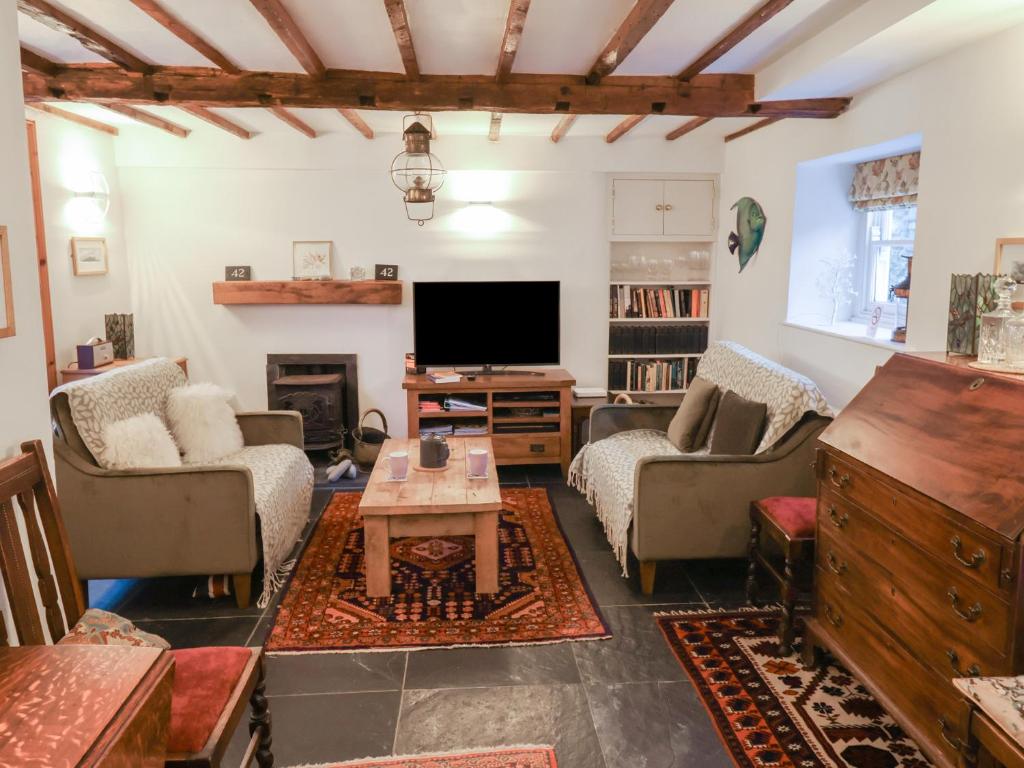 Una sala de estar con sofás y un televisor. en Naunton Cottage, en Lyme Regis