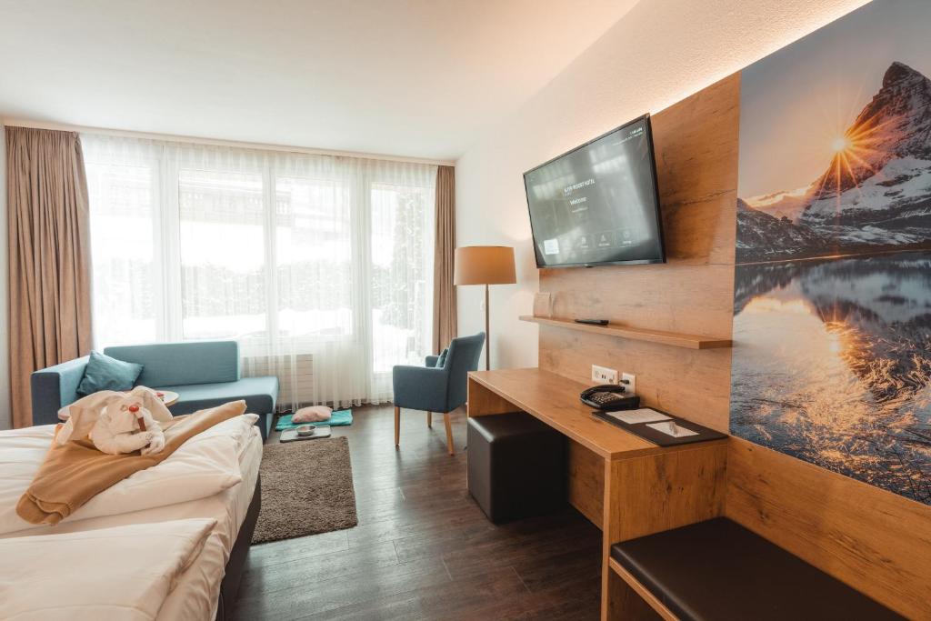ツェルマットにあるAlpen Resort & Spaのホテルルーム(犬がベッドに寝ている)