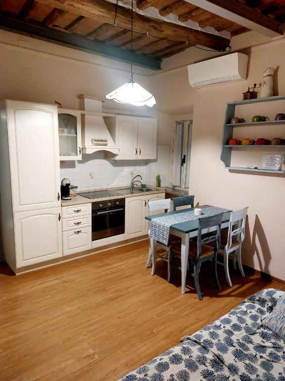 a kitchen with white cabinets and a table with chairs at La casina di Silverio in Rio Marina