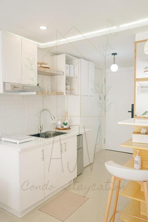 a white kitchen with white cabinets and a sink at AJV Condo Staycation in Manila