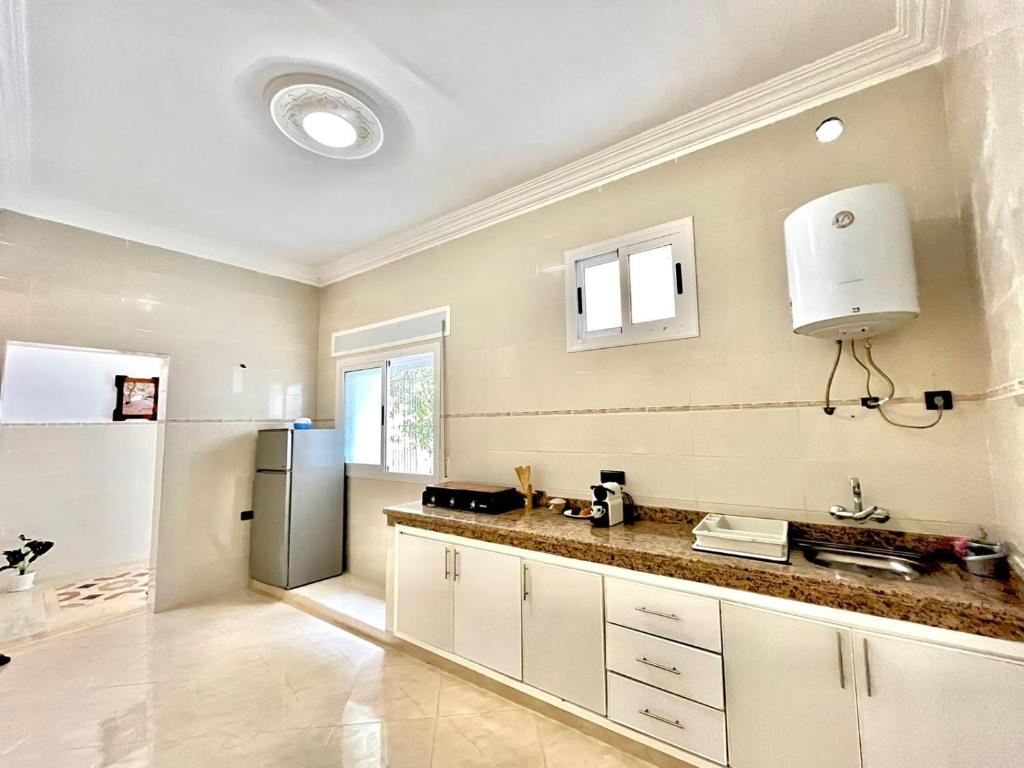 Una cocina con gabinetes blancos y un refrigerador. en Sara Apartment Parking free, en Chefchaouen
