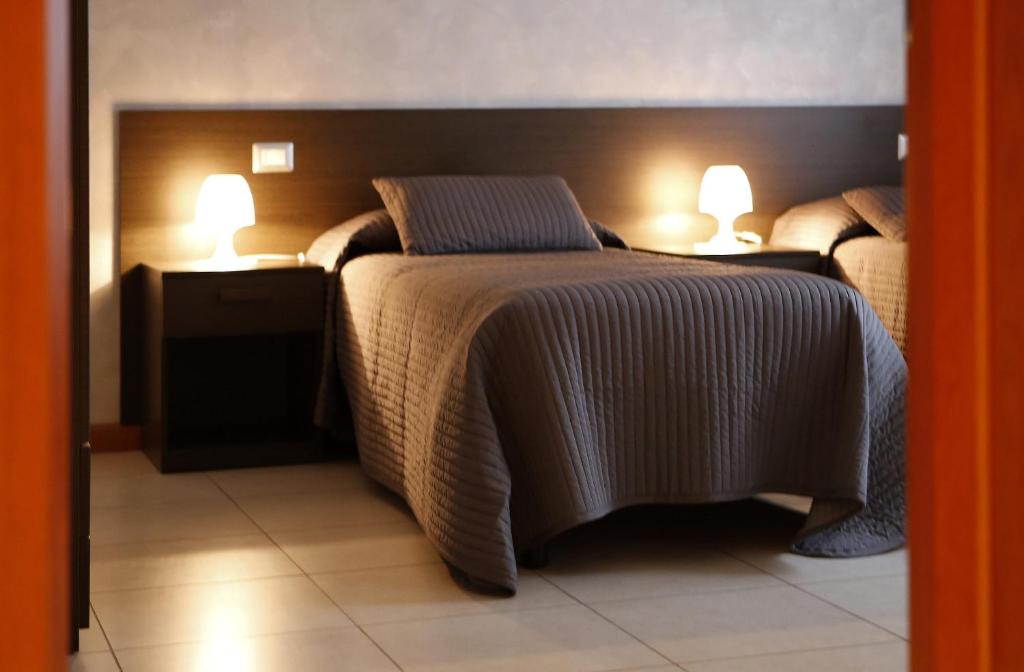 ヴェローナにあるB&B Il Sasso Anticoのベッドルーム1室(ベッド2台、ランプ2つ付)