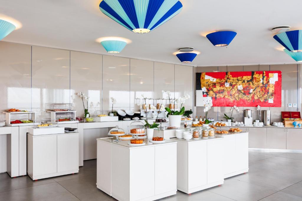 a large kitchen with white counters with food at JR Hotels Bari Grande Albergo delle Nazioni in Bari