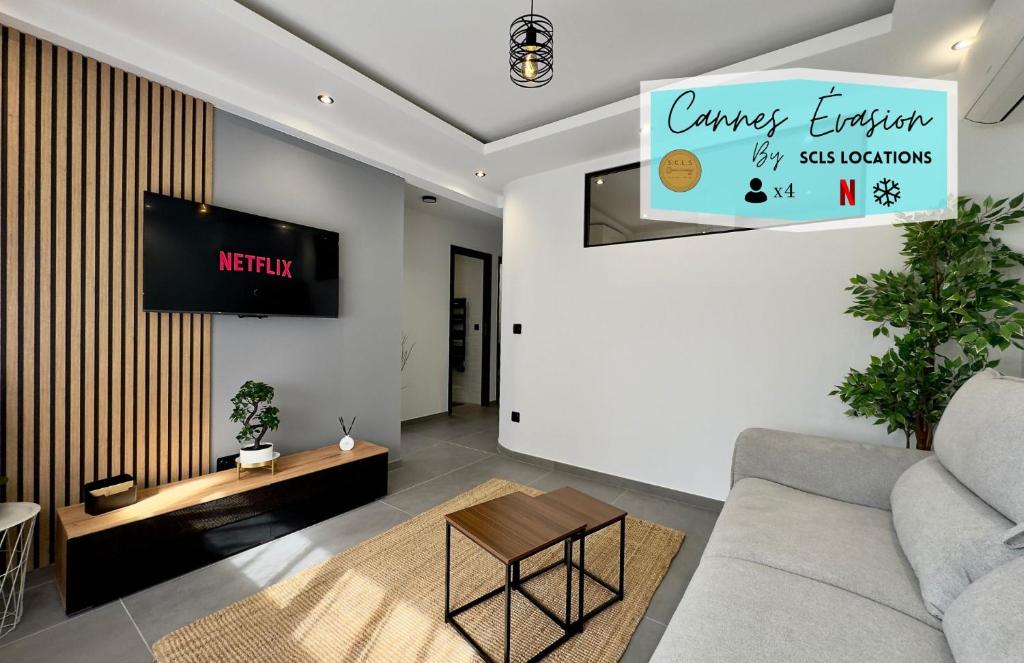 un salon avec un canapé et une télévision dans l'établissement Cannes Évasion by SCLS Locations, à Cannes