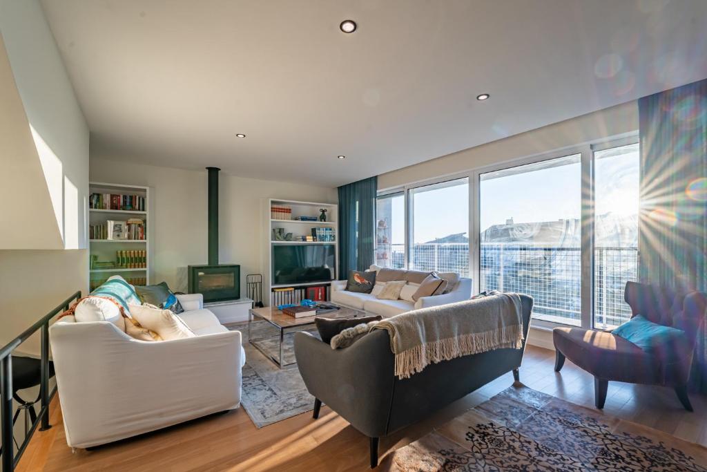 een woonkamer met witte meubels en een groot raam bij Nomads Lux - 3BDR Foz Velha Porto in Porto