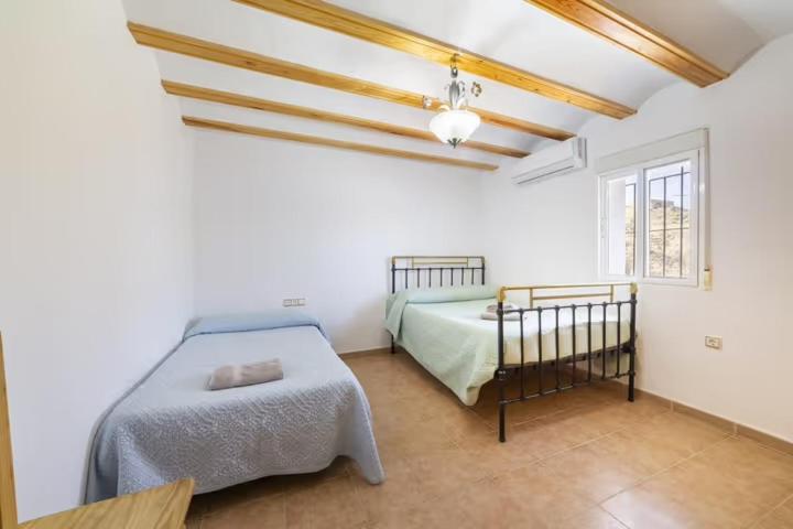 sypialnia z łóżkiem i oknem w obiekcie Casa Rural Las Cales w mieście Vélez Rubio