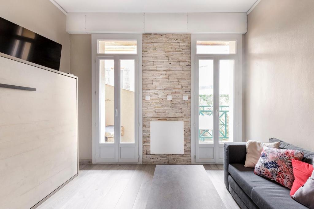 un salon avec un canapé et un mur de briques dans l'établissement Studio Toulouse centre Matabiau, à Toulouse