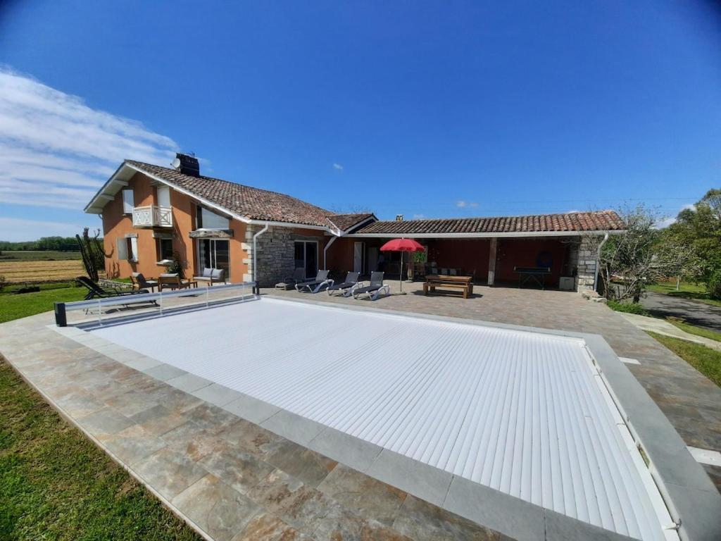 une piscine dans l'arrière-cour d'une maison dans l'établissement Villa de Campagne au bord de l'Adour, à Saint-Laurent-de-Gosse