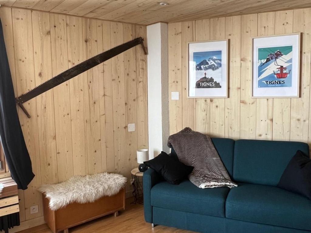- un canapé bleu dans une chambre dotée de murs en bois dans l'établissement Studio 4 pers. proche pistes et commerces, balcon, animaux acceptés - FR-1-502-417, à Tignes