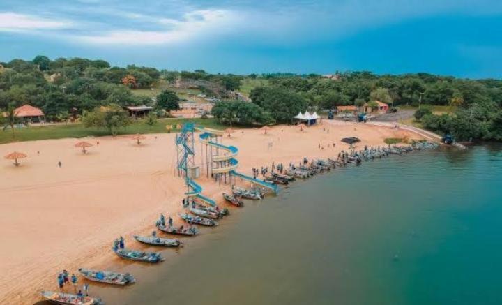 a beach with a bunch of chairs and people on it at Casa de férias Pôr do Sol in Presidente Epitácio