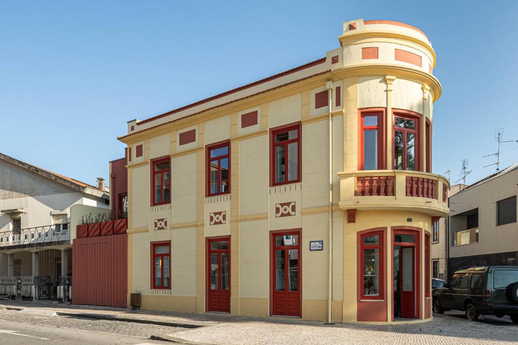 a yellow building with a round turret on a street at A'Mar by Alojamento Ideal in Póvoa de Varzim