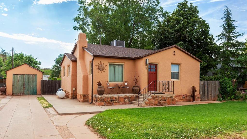 a house with a red door in a yard at Cozy Historic Family Home in Downtown Kanab Pet Friendly in Kanab