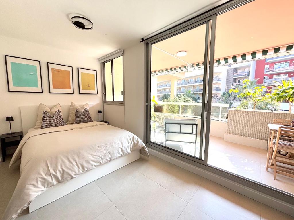 une chambre avec un lit et une grande fenêtre dans l'établissement Cosy Studio Sunny Terrace and Pool Next to the Beach and Monaco, à Roquebrune-Cap-Martin