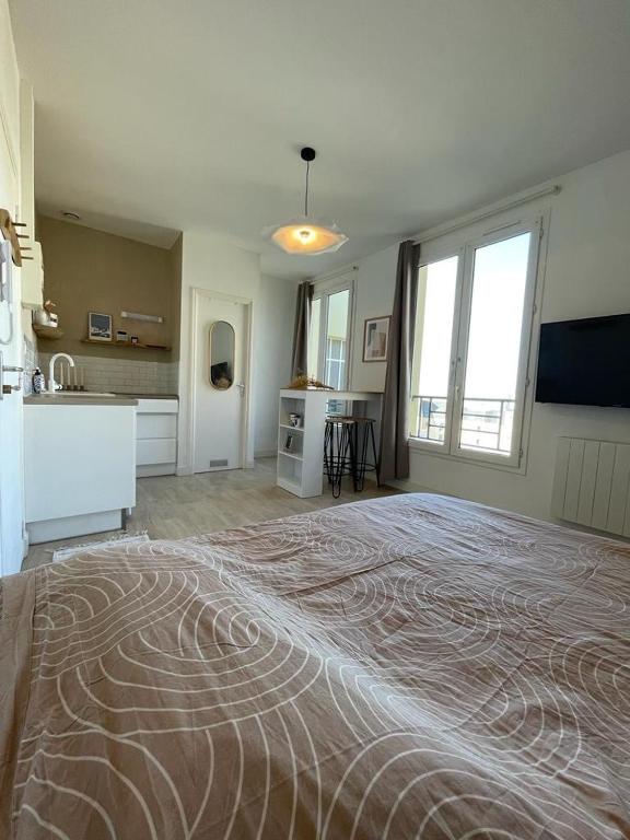 une grande chambre avec un grand lit et une cuisine dans l'établissement Studio centre ville proche plages et commerces, à Saint-Malo
