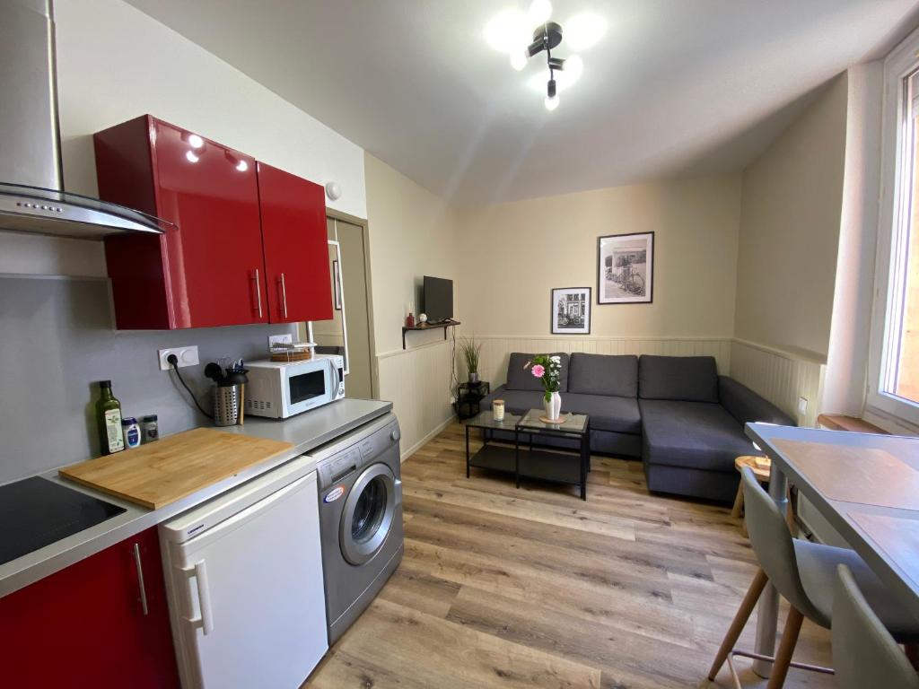 une cuisine et un salon avec un canapé dans l'établissement Henry's Place - Studio Cosy en hypercentre de Toulouse, à Toulouse