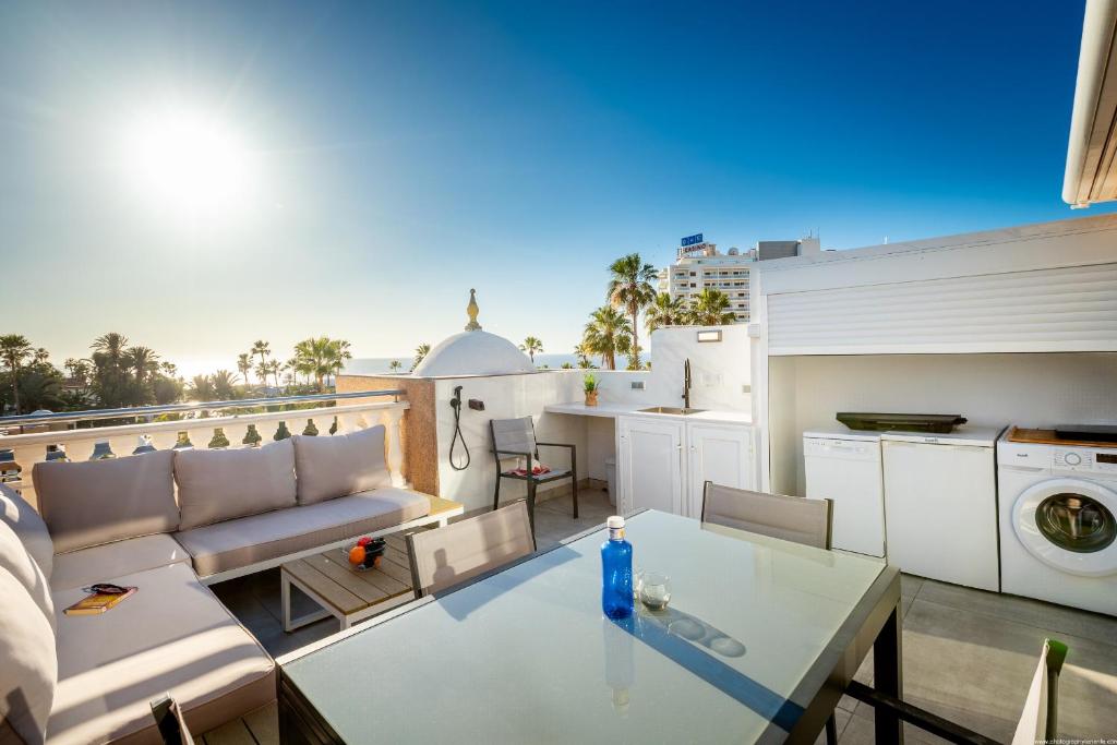 sala de estar con mesa de cristal en el balcón en Chic apartment with great terrace, en Playa de las Américas