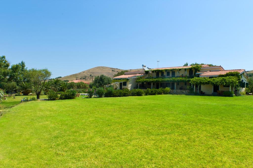 a large green field in front of a building at Villa Panorama in Moúdhros